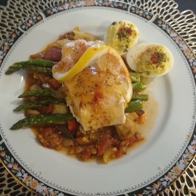 Fish with vegetables and a lemon garnish